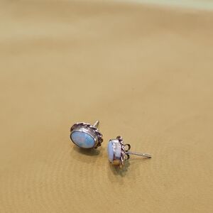 Vintage opal stud earrings set in 9 CT gold with a rope or "florette" border.